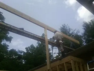 Carpenter setting a ridge beam over a new addition frame — Ice Dam Removal by Roofing Brothers in Wausaukee