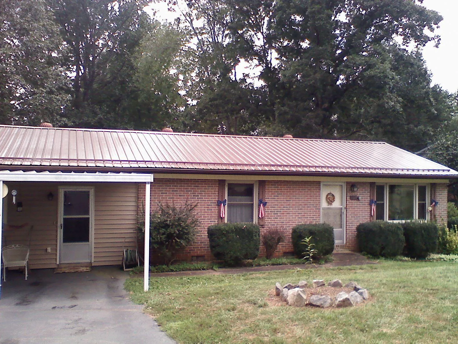 Bronze metal roof and carport on a brick ranch home — Roof Repair work by our crew in Wausaukee