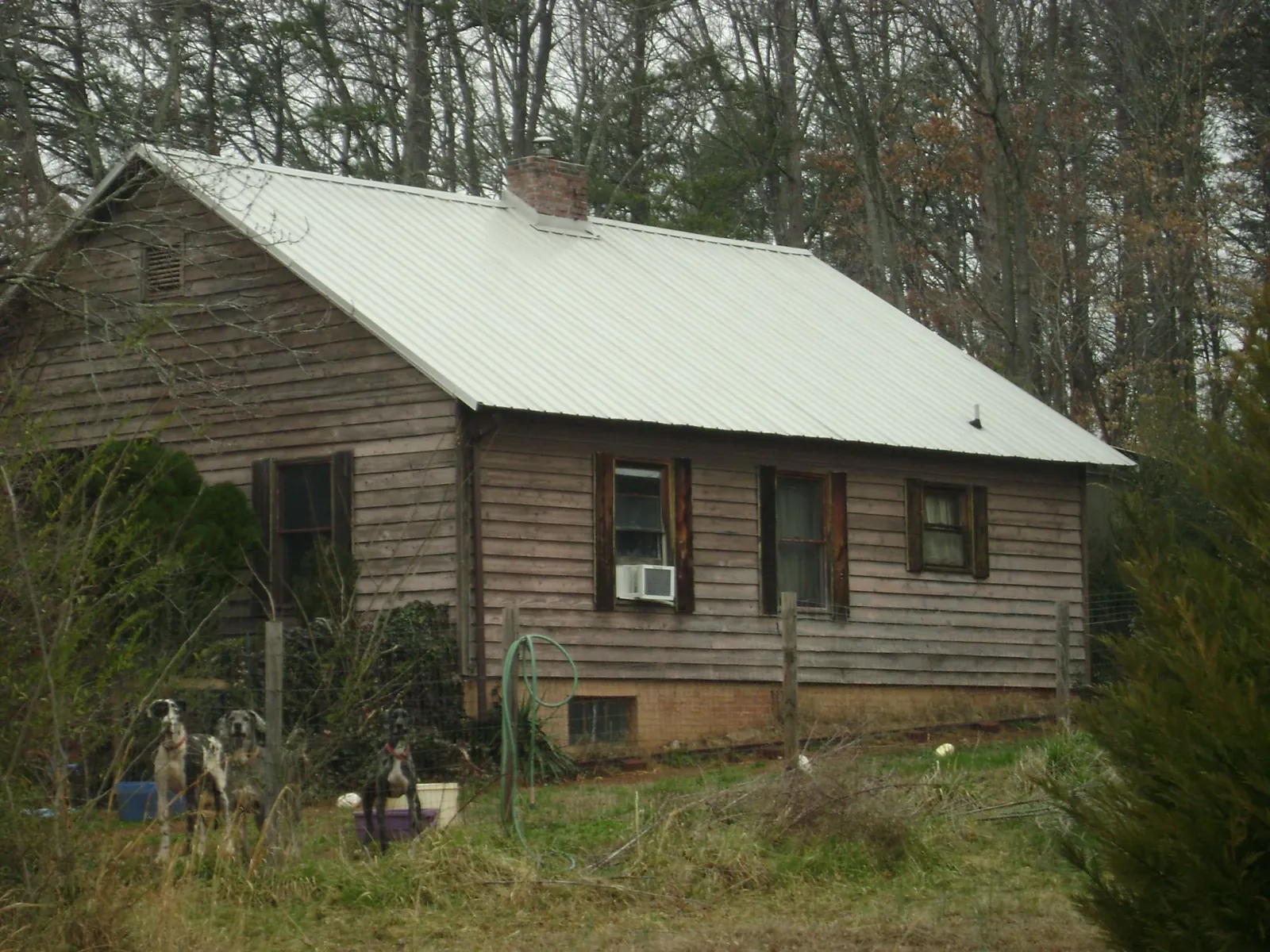 White metal roof on an old wood sided farmhouse, from a Metal Roof Installation job in Wausaukee